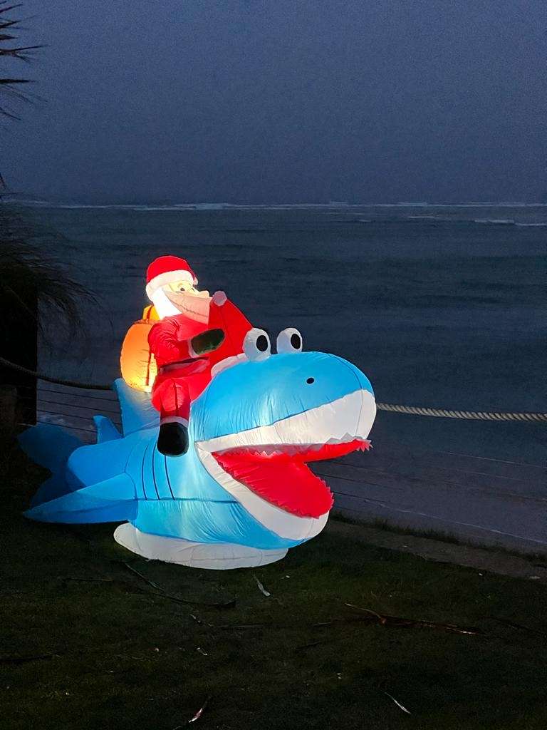 Inflatable Santa on an Inflatable Shark at night on the beach